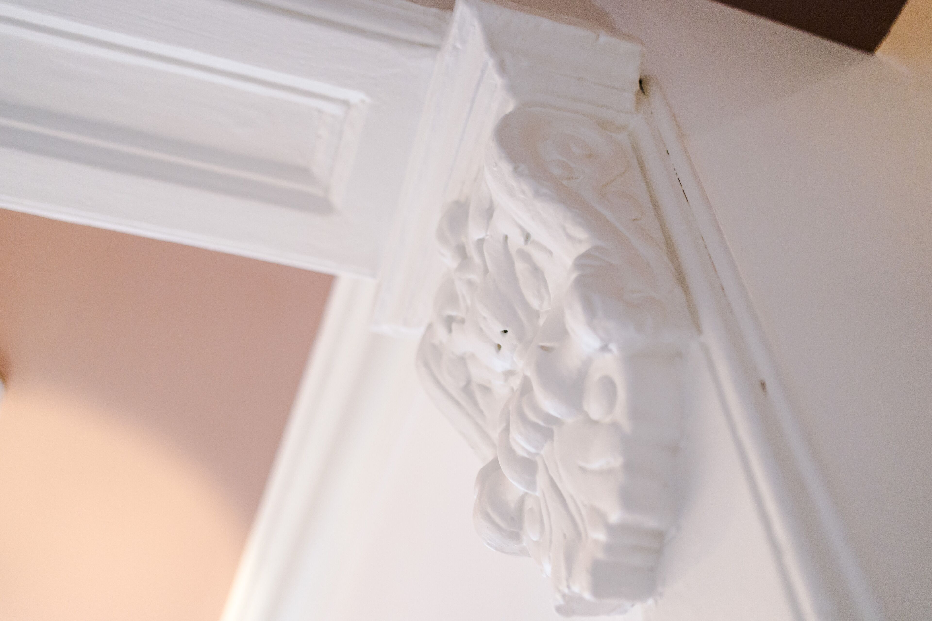 A close-up of a white architectural detail with intricate carvings.