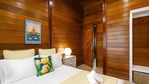 A wooden-paneled room with a bed, a nightstand, a lamp, and a painting of a Buddha. - Casa da Poesia - Private Pool (Porto de Mós)