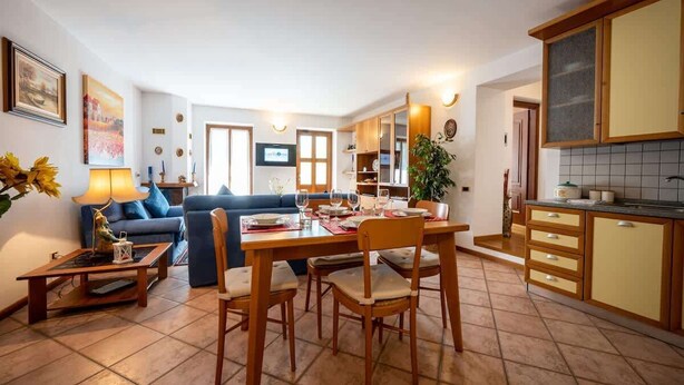 A modern living room with a dining area, a kitchen, and a TV. - Lakefront Haven: Apartment w/ Balcony & Bike A24 by Larihome (Dongo)