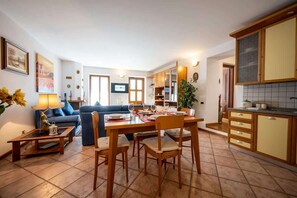 A modern living room with a dining area, a kitchen, and a TV. - Lakefront Haven: Apartment w/ Balcony & Bike A24 by Larihome (Dongo)