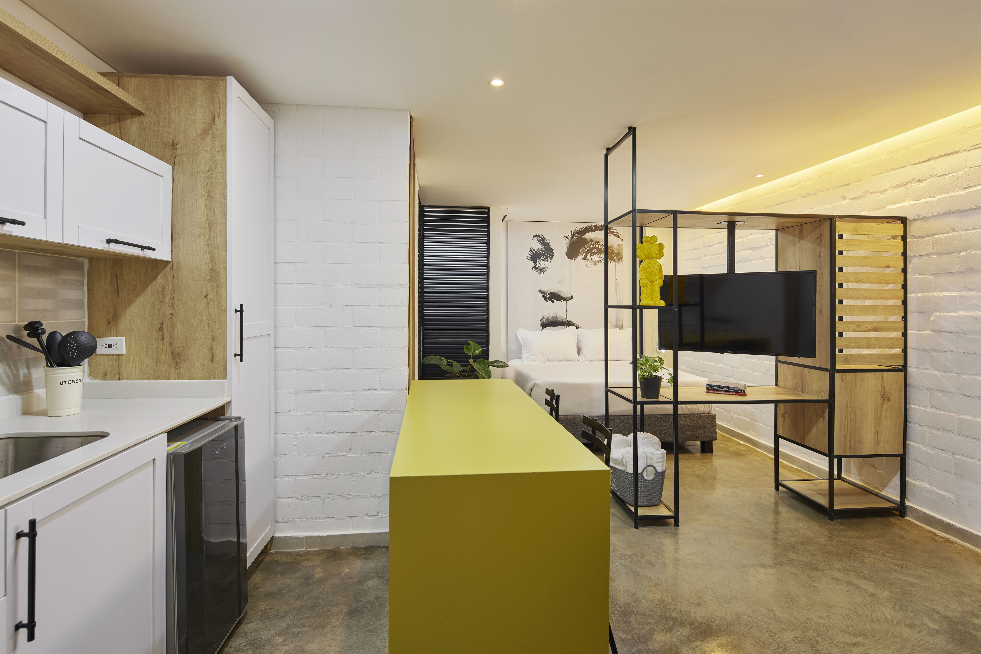 A modern kitchen with white cabinets, a yellow countertop, and a built-in dishwasher.