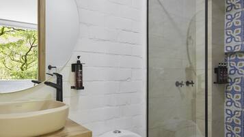 A bathroom with a white sink, a toilet, and a glass-enclosed shower.