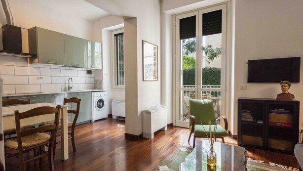 Una cocina moderna con comedor, lavadora y un amplio ventanal.
