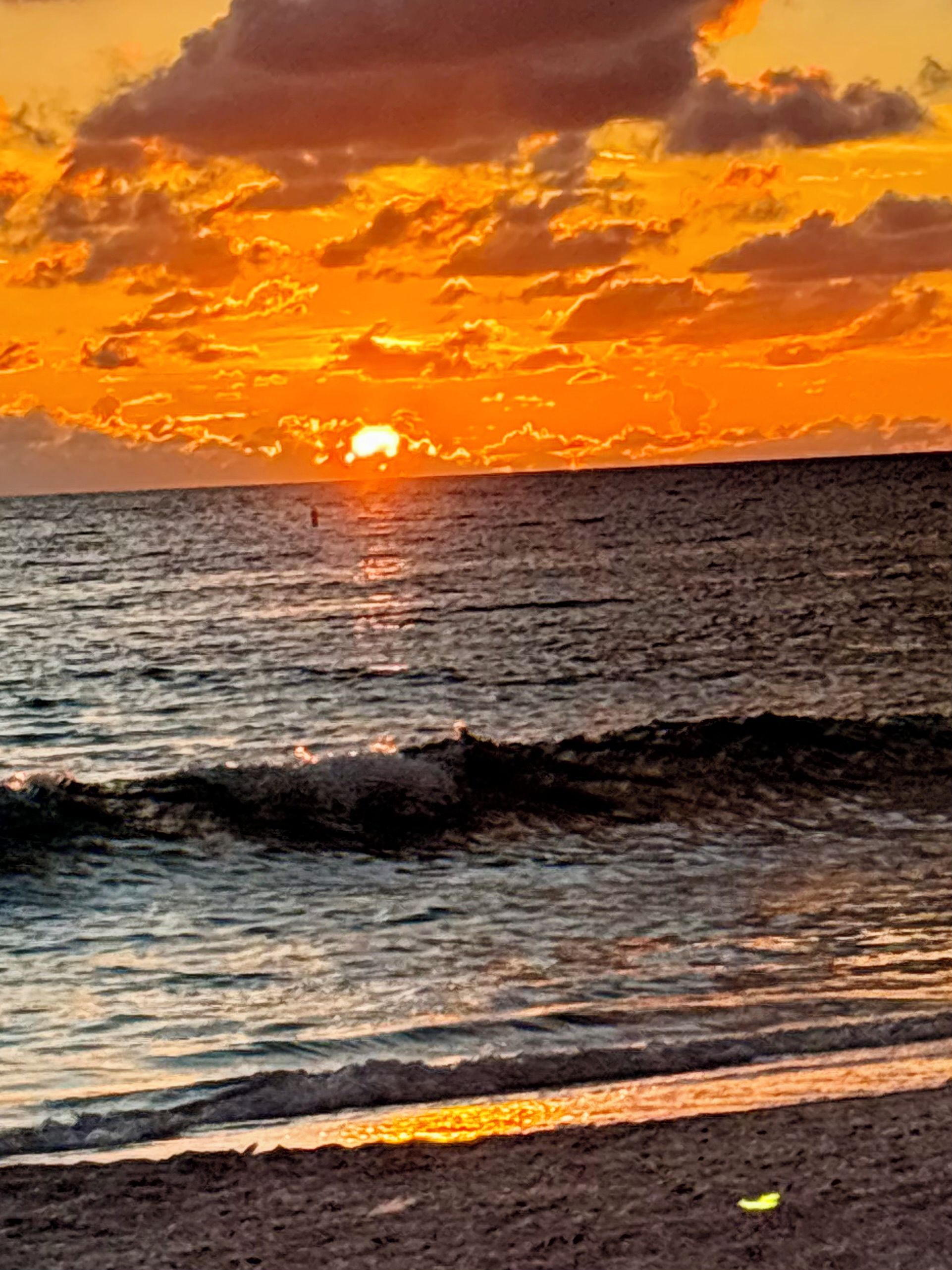 Ein Sonnenuntergang über dem Meer mit Wellen.