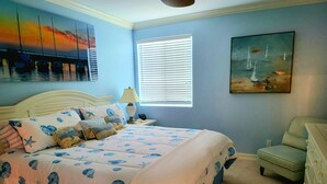 A bedroom with a bed, a nightstand, a lamp, a window with blinds, and a painting on the wall. - Memories Await, Garber Getaways! Waterfront retreat, 100 steps to private beach! (Naples)