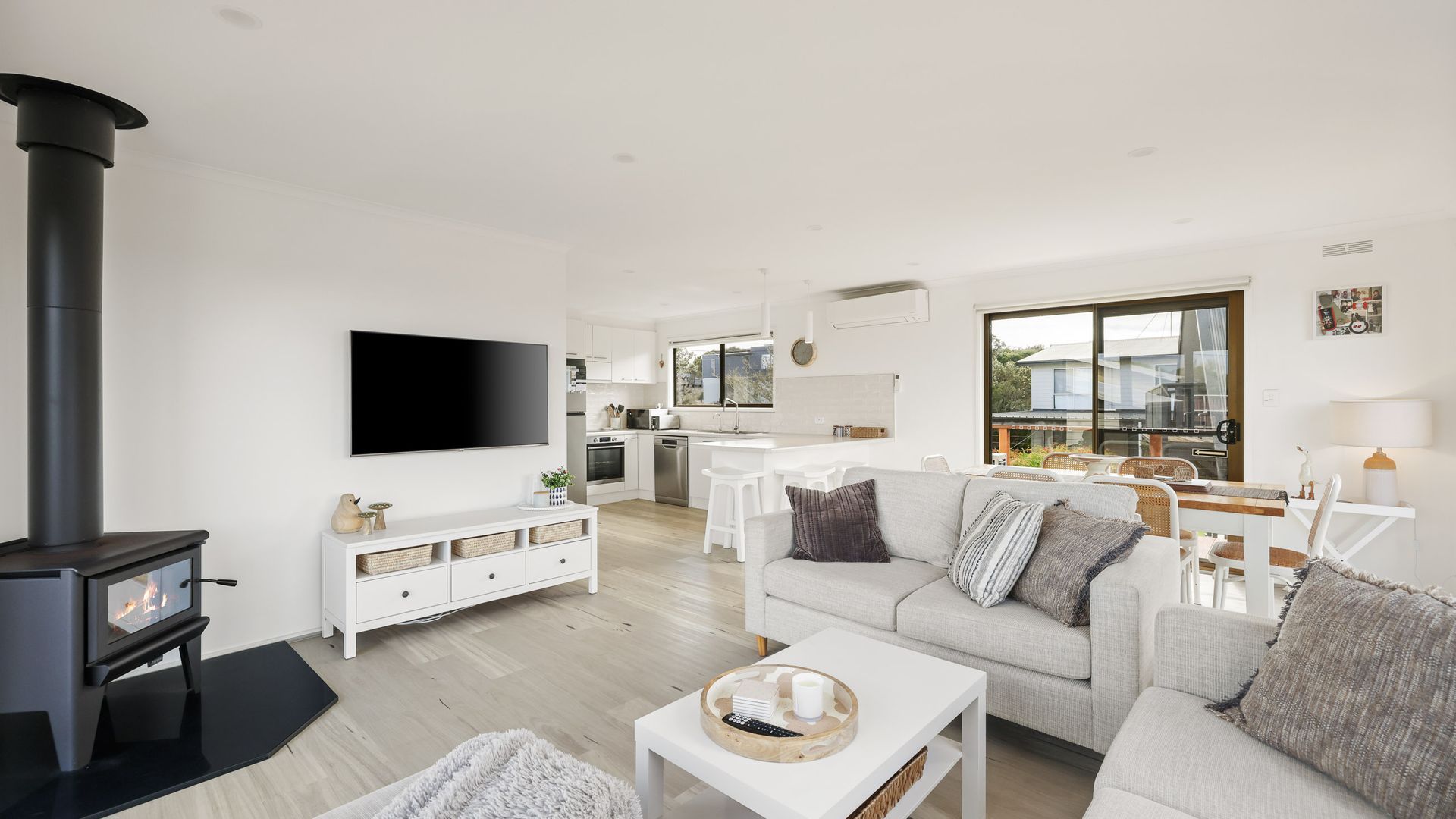 A modern living room with a fireplace, a sofa, a coffee table, and a TV.