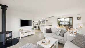 A modern living room with a fireplace, a sofa, a coffee table, and a TV.