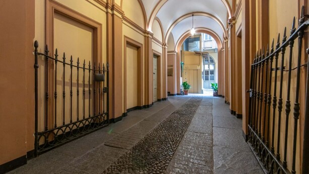 A corridor with arched ceilings, a stone floor, and metal railings. - GuestHost - Consolata Square Elegant Loft x4 (Torino)