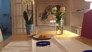 Ett matbord med en tallrik mat, en vas med blommor och en blå behållare.