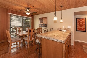 Enjoy meals in this inviting kitchen with a central island, pendant lights, and a dining table.