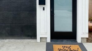 A modern house with a dark garage door, a black front door with a glass panel, and a mailbox. - Birdie's: A New 2b in Downtown Hillsboro (Hillsboro)
