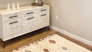 A room with a white textured cabinet, a patterned rug, and two framed artworks on the wall. - Birdie's: A New 2b in Downtown Hillsboro (Hillsboro)