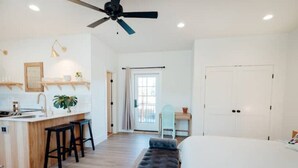 A modern, well-lit room with a kitchen area, a bench, and a door leading to another room. - The Isabella Lofthouse on Colorado-Walk to Main

 (Buena Vista)