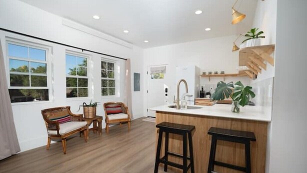 A modern kitchen with a central island, wooden flooring, and large windows. - The Isabella Lofthouse on Colorado-Walk to Main

 (Buena Vista)