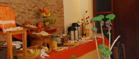 A buffet table with various food items and a coffee maker.