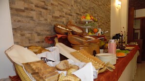 A buffet table with various food items and a decorative snake sculpture. - HOTEL PUNO TERRA (Puno)