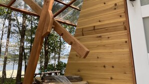 A wooden structure with a glass roof, a stack of firewood, and a door with a keyhole. - Lakefront Transforming Micro Cottage on Cherokee Lake  (Mooresburg)