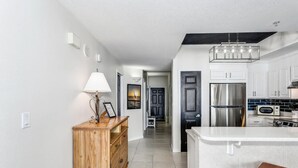A modern kitchen with a central island, stainless steel appliances, and a wooden cabinet.