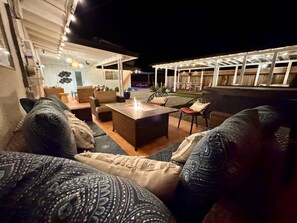 Un espace extérieur aménagé avec un foyer, des canapés et des fauteuils.