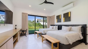 Un dormitorio moderno con dos camas, un escritorio y vistas a zonas verdes.