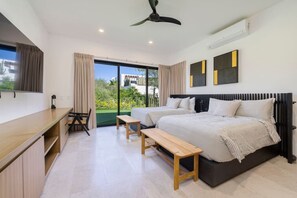 Un dormitorio moderno con dos camas, un escritorio y vistas a zonas verdes.