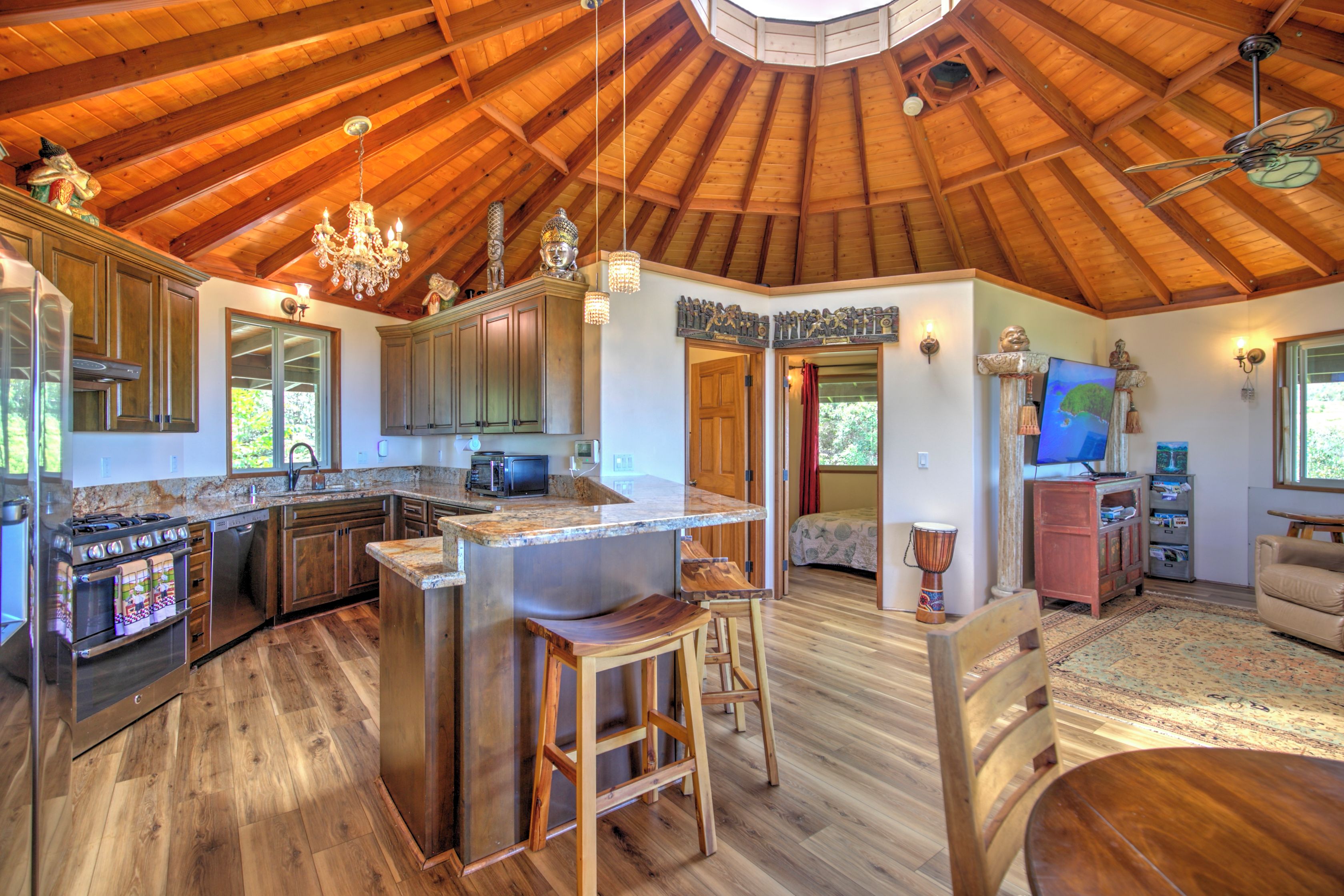 A spacious kitchen with wooden beams, a central island, and modern appliances.