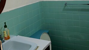A small bathroom with a white sink, a toilet, and a mirror. - Hospedaje Casa de Luna (Tegucigalpa)