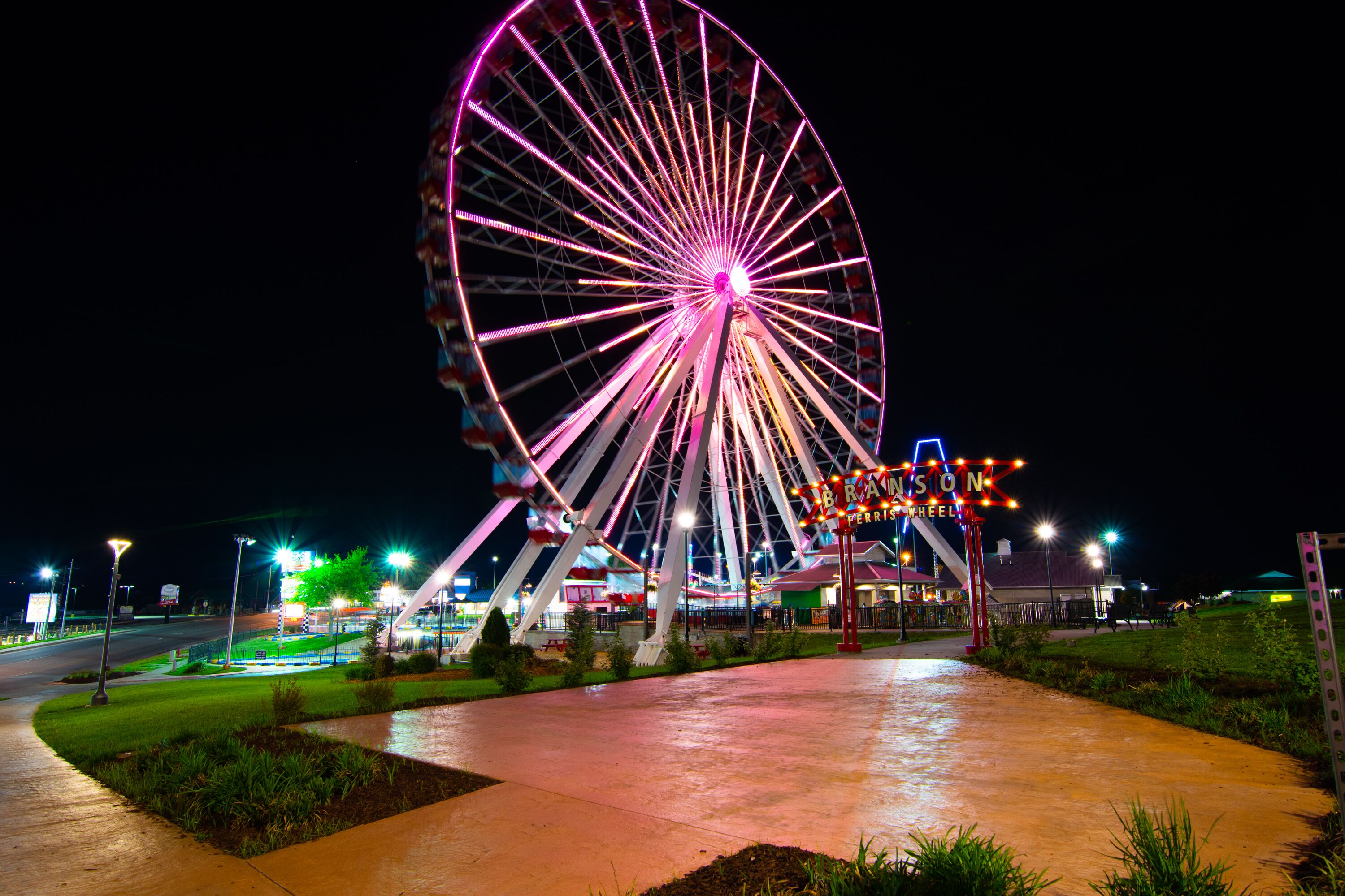 A large Ferris wheel with a sign that reads "BRADSON TERRACE" at night.