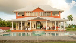 A two-story house with a swimming pool in front. - Affordable Ariyana sleeps 10 in Tobago Plantations (Lowlands)