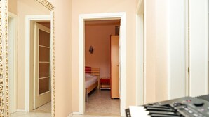 A narrow hallway with a bed and a wardrobe in a room. - Entire Apartment in the Center of Tirana (Tirana)