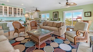 A spacious living room with a large coffee table, comfortable seating, and a view of the outside. - Sea Urchins, North & South Units. 10 BR 10BA. Beachview. The Beach, so close, for less! Pool. (Gulf Shores)