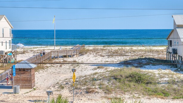 A beachside property with a wooden deck, beach access sign, and a view of the ocean. - Sea Urchins, North & South Units. 10 BR 10BA. Beachview. The Beach, so close, for less! Pool. (Gulf Shores)