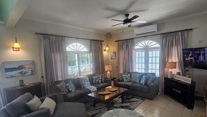 Una sala de estar con un sofá, una mesa de centro y un televisor.