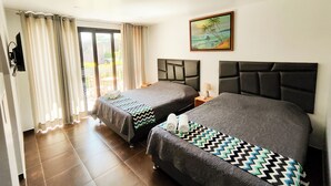 A hotel room with two beds, a painting, a TV, and a balcony with curtains. - Jalara Lunahuaná Hotel (Lunahuana)