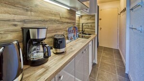 A kitchen with a wooden countertop, a coffee maker, a toaster, and a sink. - Vostok Zodiaque by Interhome (Le Corbier)