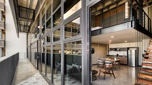 A modern interior with a long hallway, large windows, a dining area, and a kitchen. - Downtown Loft by ULIV (Tijuana)