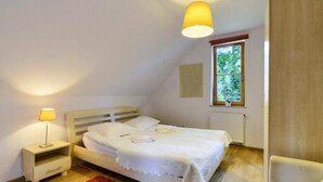 A bedroom with a bed, bedside table, lamp, window, and radiator. - 3 bedroom pet friendly home in Karpacz (Karpacz)
