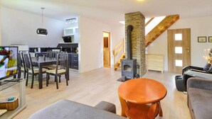 A spacious living area with a kitchen, dining table, and a fireplace. - 3 bedroom pet friendly home in Karpacz (Karpacz)