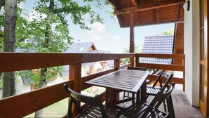 A wooden deck with a table and chairs, overlooking a residential area. - 3 bedroom pet friendly home in Karpacz (Karpacz)
