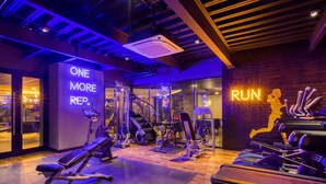A gym with exercise equipment, a mirrored wall, and motivational neon signs. - Downtown Designer Apartments by ULIV (Tijuana)