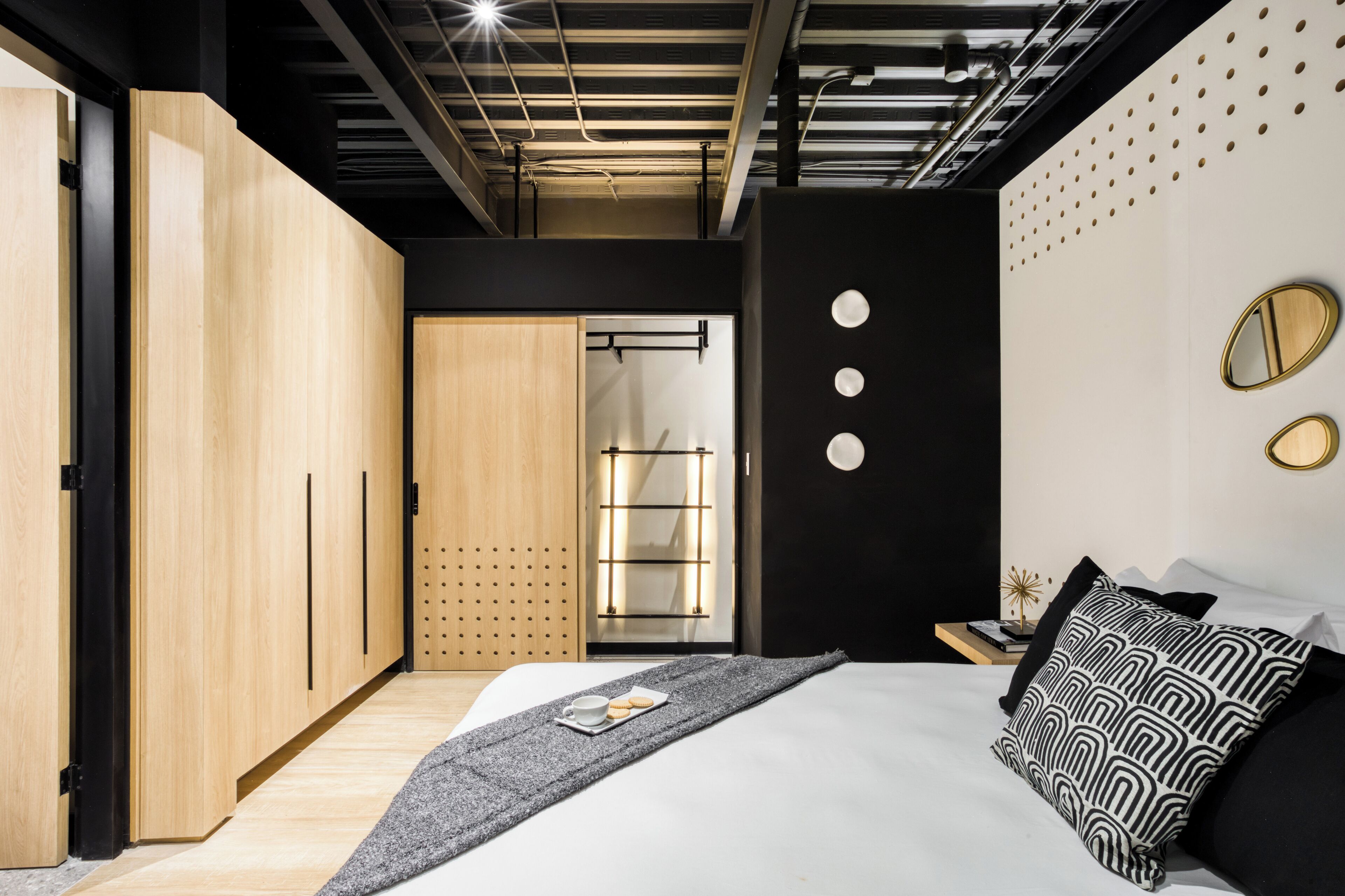 A modern bedroom with a bed, bedside tables, and a wardrobe.
