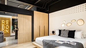 A modern bedroom with a bed, a wooden wardrobe, and a wall with circular light fixtures. - Downtown Designer Apartments by ULIV (Tijuana)