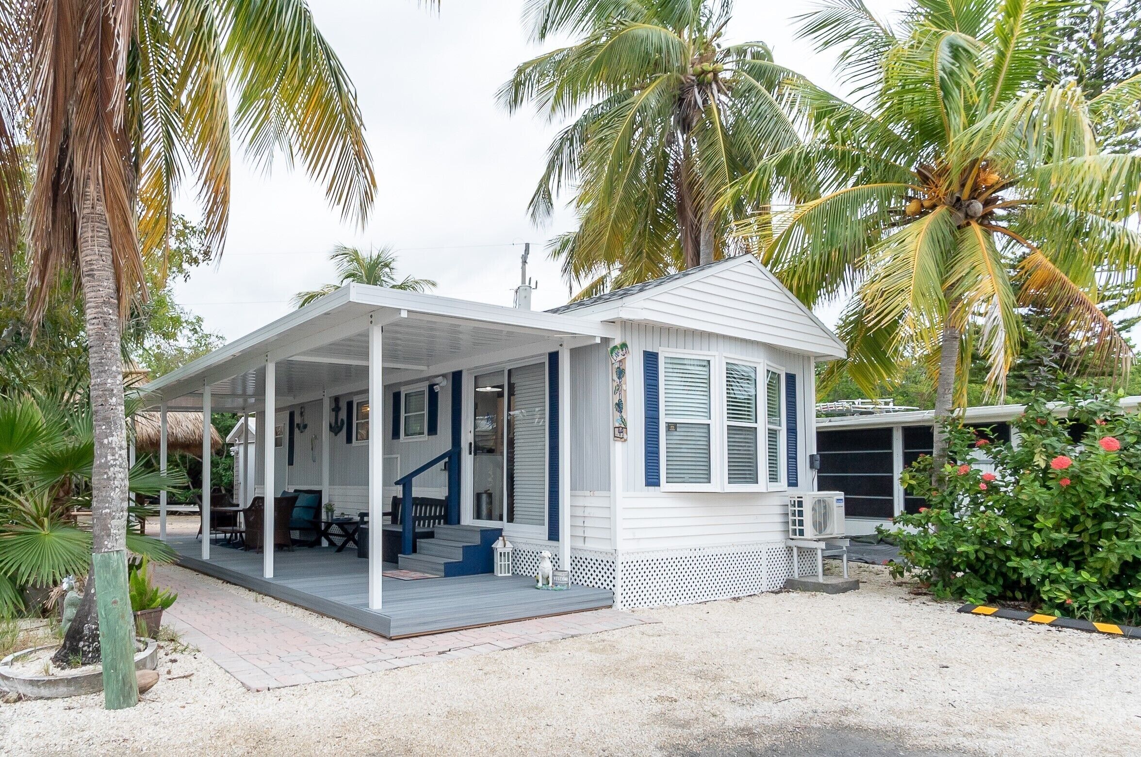 A small, single-story house with a covered porch and a small deck.