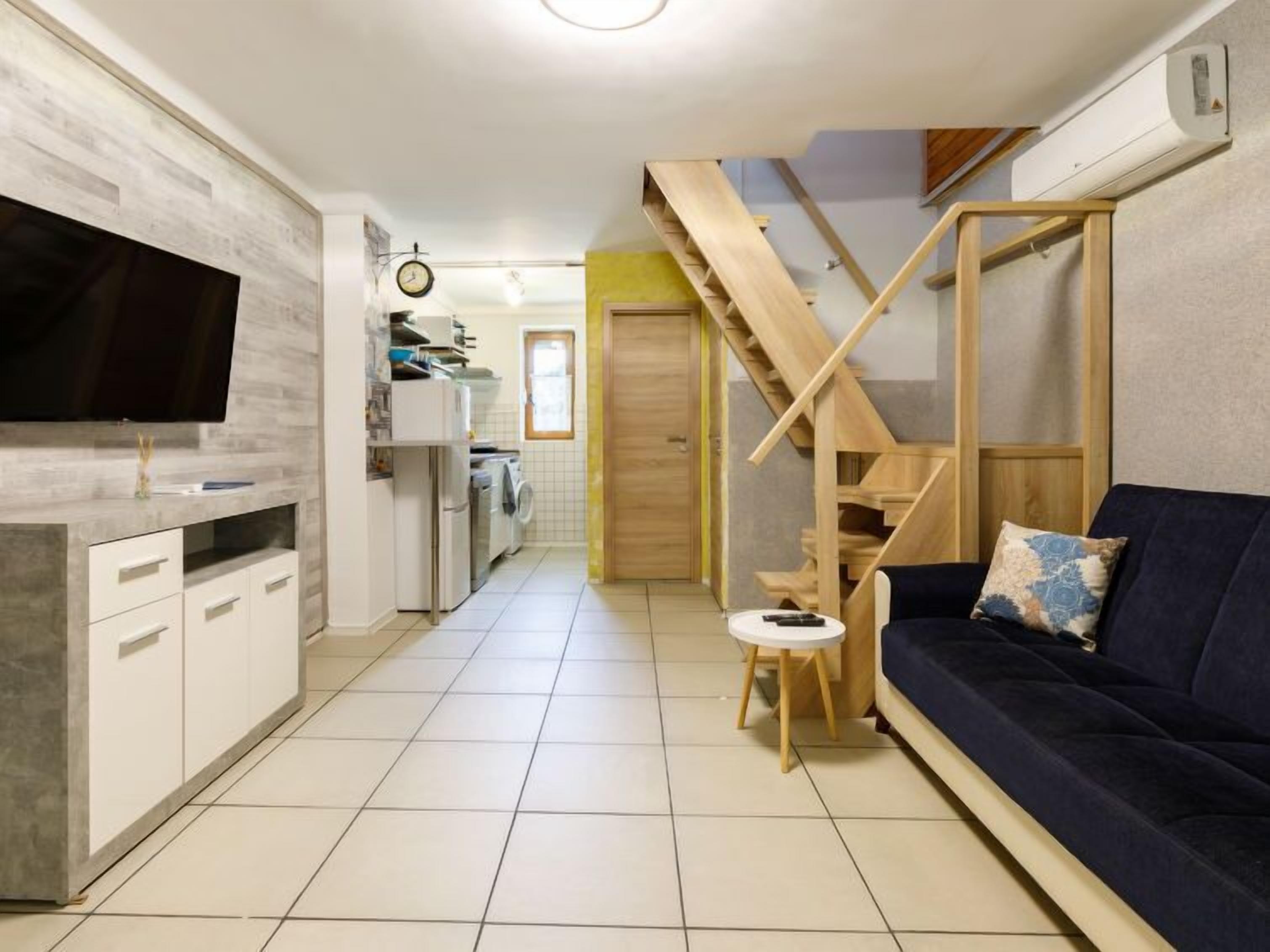 Un apartamento moderno con cocina, sala de estar y una escalera.
