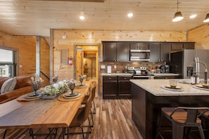 Enjoy cooking and dining in this well-equipped kitchen with a dining table for four, a cozy seating area, and a convenient island with bar stools.