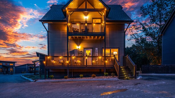 A two-story building with a balcony and a staircase leading to the entrance. - SummerFun! Pets, Indoor Pool, Fire Pit, Hot Tub, Foosball/Air Hockey, Dollywood! (Sevierville)