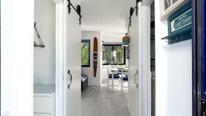 Un couloir décoré avec un bateau en bois, un coin repas avec une table et des chaises, et une enseigne publicitaire pour des boissons fraîches.