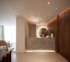 A modern interior with a reception desk, a circular wall feature, and wooden paneling.