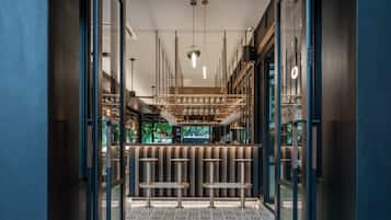 A modern bar with a patterned floor and a sign reading 'THE MANI BAR'.