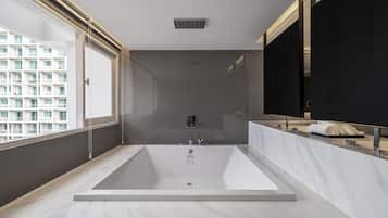 A modern bathroom with a large bathtub, a glass shower enclosure, and a large mirror.